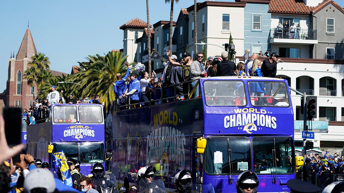 Buses carrying Los Angeles Rams players and coaches drive past fans during the team's victory parade in Los Angeles, Wednesday, Feb. 16, 2022, following their win Sunday over the Cincinnati Bengals in the NFL Super Bowl 56 football game.