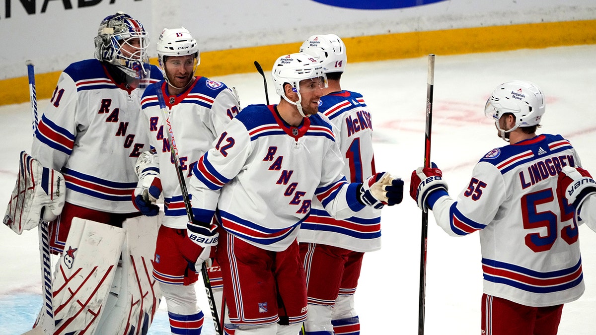 New York Rangers celebrate their win over the Ottawa Senators during third-period NHL hockey game action in Ottawa, Ontario, Sunday, Feb. 20, 2022.