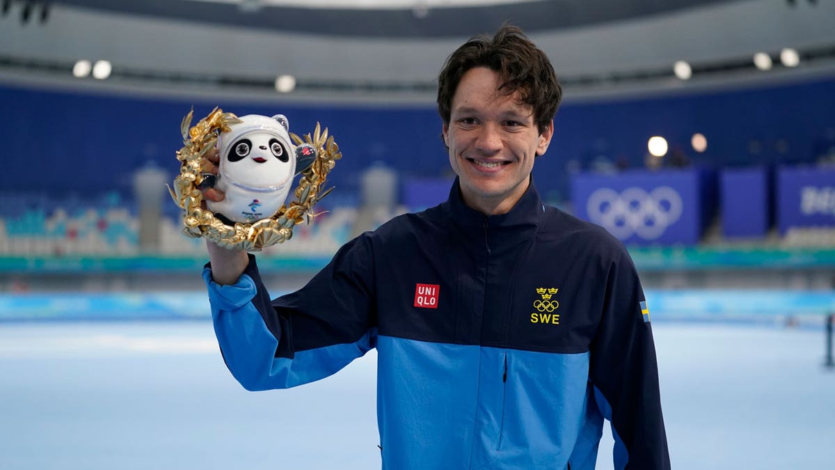 Nils van der Poel of Sweden, poses during a venue ceremony after winning the gold medal and breaking his own world record in the men's speedskating 10,000-meter race at the 2022 Winter Olympics, Friday, Feb. 11, 2022, in Beijing.