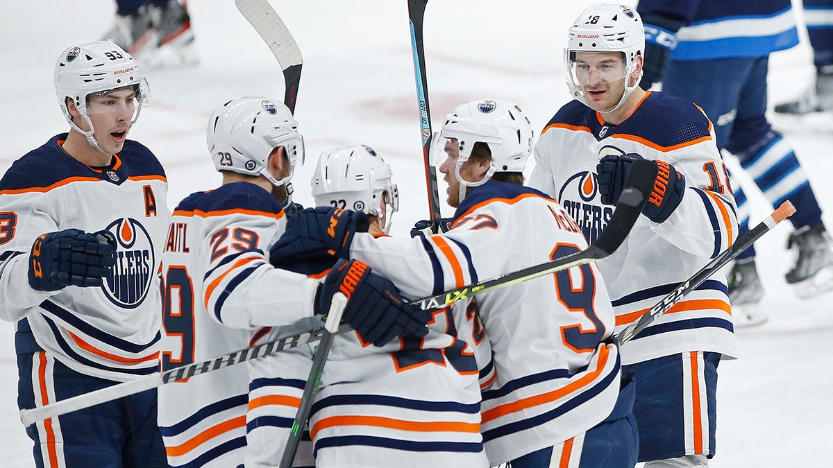 Edmonton Oilers' Zach Hyman (18) celebrates his goal against the Winnipeg Jets with teammates Ryan Nugent-Hopkins (93), Leon Draisaitl (29), Tyson Barrie (22), and Connor McDavid (97) during the first period of an NHL hockey game in Winnipeg, Manitoba, Saturday, Feb. 19, 2022.
