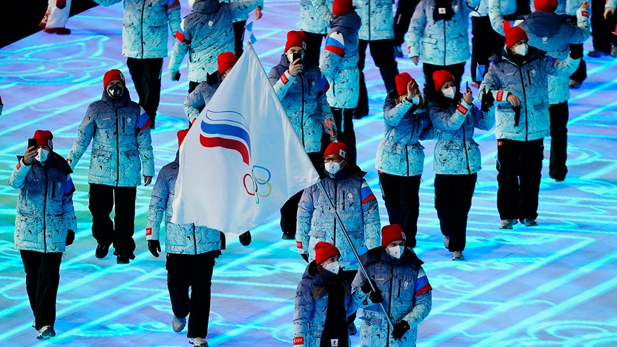 Olga Fatkulina and Vadim Shipachyov of the Russian Olympic Committee carry a flag into the stadium during the opening ceremony of the 2022 Winter Olympics, Friday, Feb. 4, 2022, in Beijing.