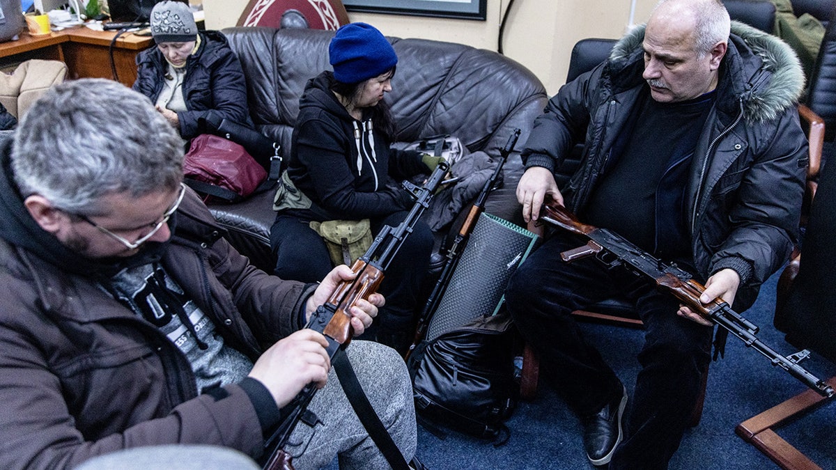 Civilian volunteers check their guns at a Territorial Defence unit registration office on February 26, 2022 in Kyiv, Ukraine. 