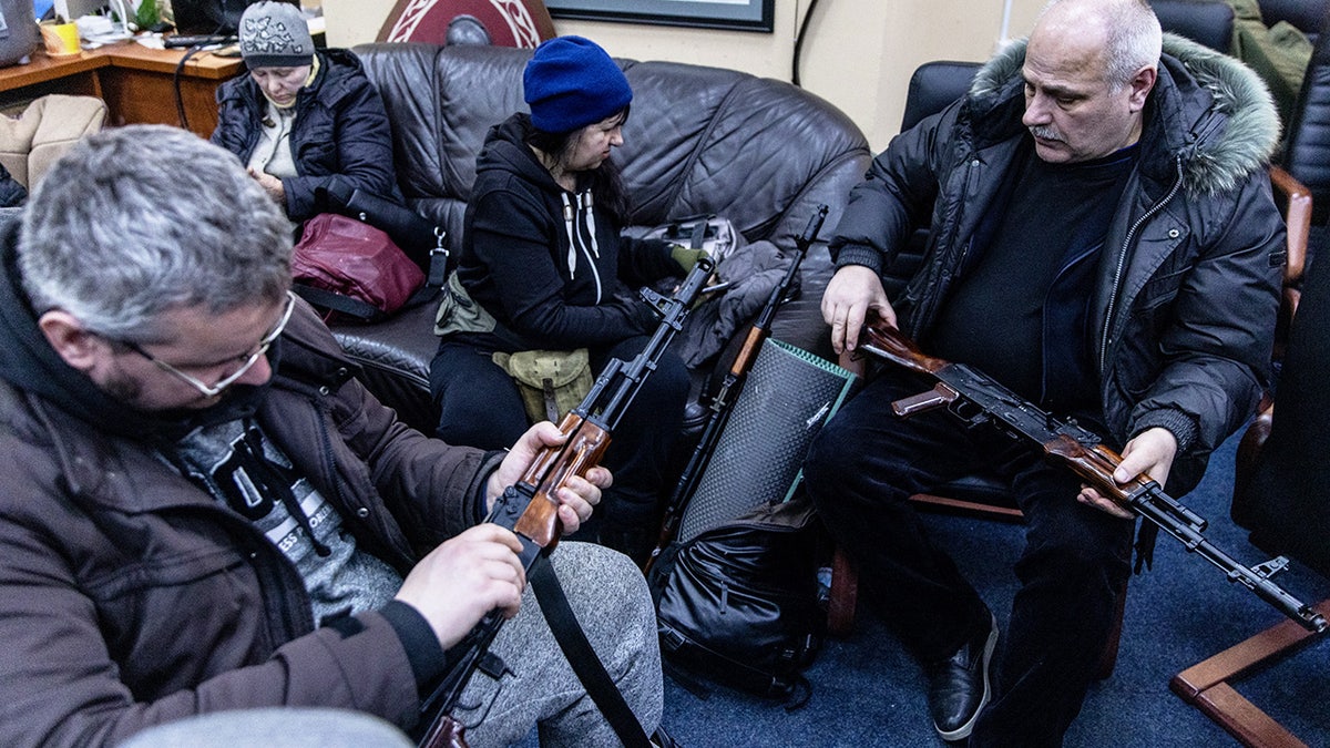 Civilian volunteers check their guns at a Territorial Defence unit registration office on February 26, 2022 in Kyiv, Ukraine.
