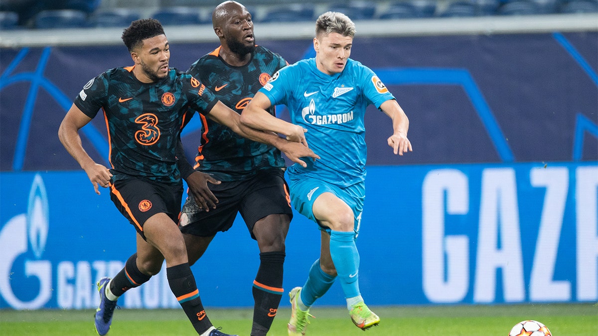 Andrey Mostovoy of Zenit St. Petersburg dribbles past Reece James (left) and Romelu Lukaku (right) of Chelsea FC during the UEFA Champions League group H match between Zenit St. Petersburg and Chelsea FC at Gazprom Arena on Dec. 8, 2021 in Saint Petersburg, Russia. 