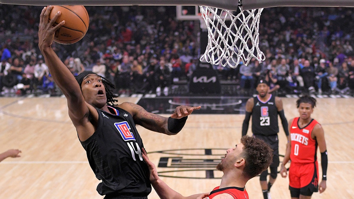 Los Angeles Clippers guard Terance Mann, left, shoots as Houston Rockets center Alperen Sengun defends during the first half of an NBA basketball game Thursday, Feb. 17, 2022, in Los Angeles.