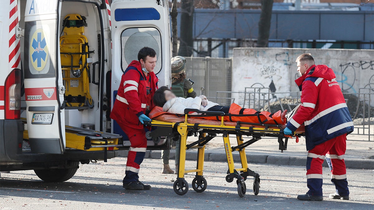 Medical specialists transport a wounded woman to an ambulance after recent shelling in Kyiv, Ukraine February 26, 2022.