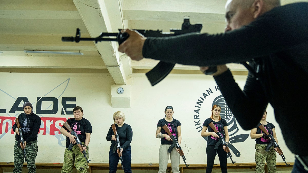 An instructor shows how to use weapons to a group of women during training in Kharkiv, Ukraine, Sunday, Jan. 30, 2022. 