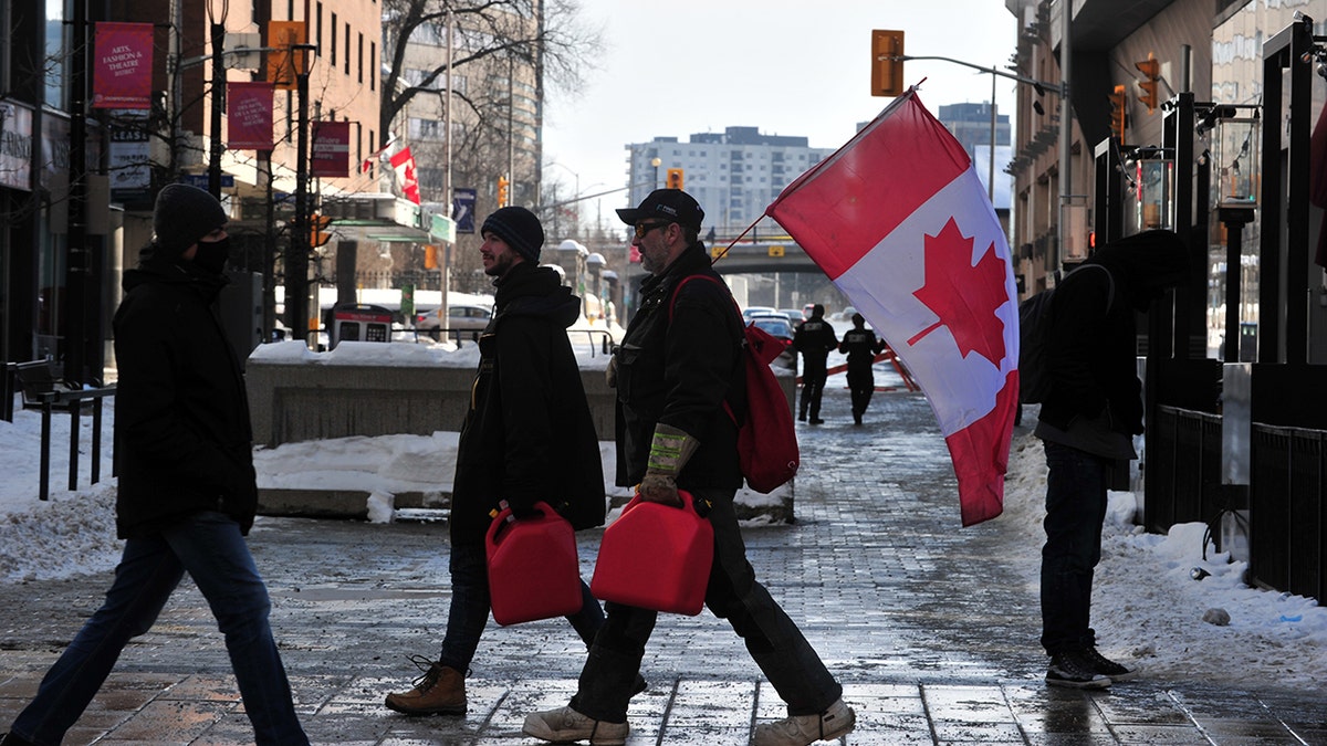  Truckers carry jerrycans to refuel as truckers continue to protest vaccine mandates against Covid-19, in Ottawa, Canada on February 7, 2022. Ottawa has declared a state of emergency after the long protests by truck drivers over vaccine mandates and Covid-19 restrictions. 