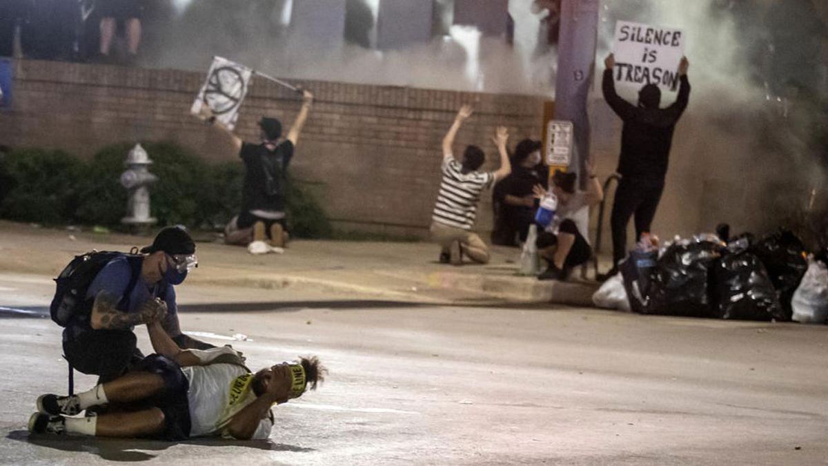 In this May 30, 2020 file photo, people help a protester after he was shot with a rubber bullet under Interstate 35 freeway in Austin Texas while protesting the death of George Floyd.?