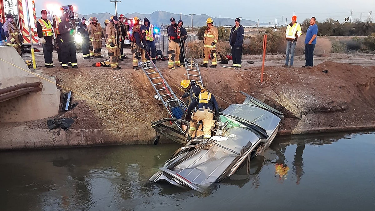 Firefighters in Arizona rescued a person trapped inside a crushed car after it crashed into a canal and began to sink, officials said on Monday.