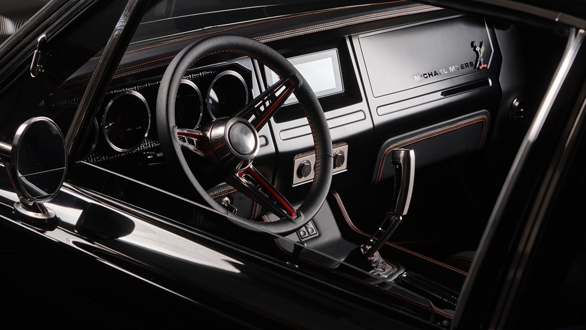 The interior features a 3D-printed dashboard and knife-style shifter.