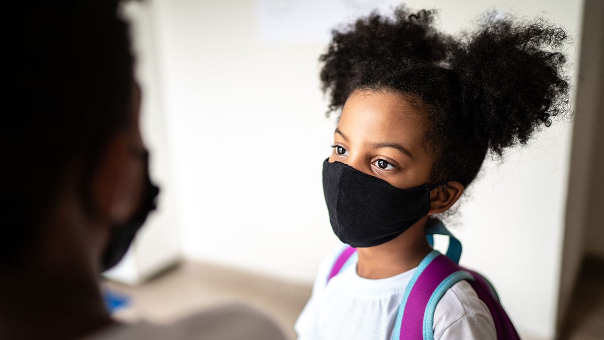 Friends wearing face mask talking during break time at school.