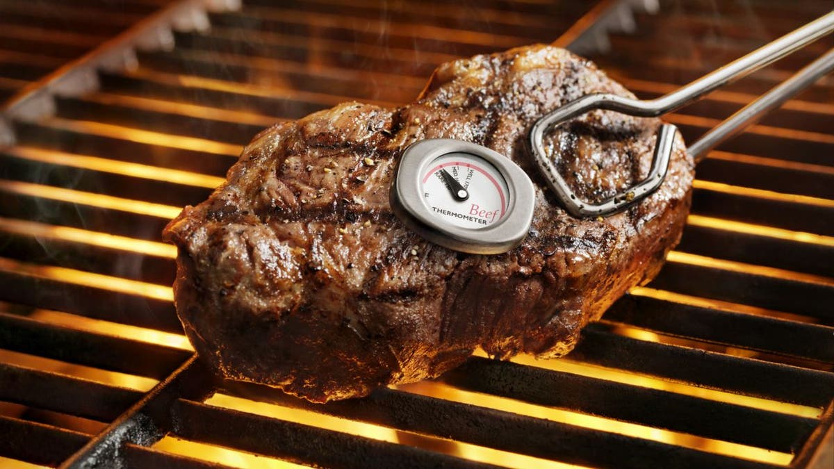 Steak on a grill with a thermometer