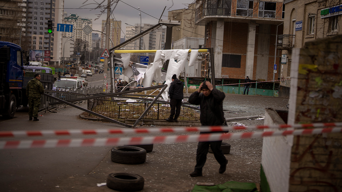 Police officers inspect area after an apparent Russian strike in Kyiv Ukraine, Thursday, Feb. 24, 2022. Russian President Vladimir Putin on Thursday announced a military operation in Ukraine and warned other countries that any attempt to interfere with the Russian action would lead to "consequences you have never seen."