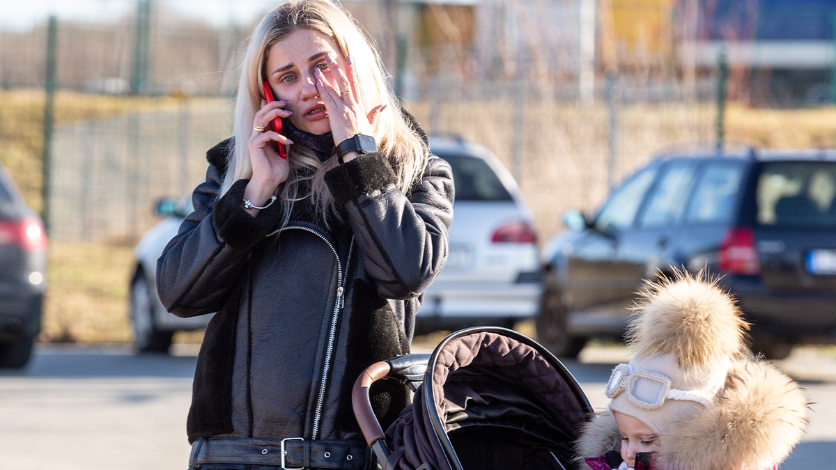 An Ukrainian mother cries after crossing to Poland as first migrants from Ukraine enter Poland after Russia bombarded Ukrainian territory.