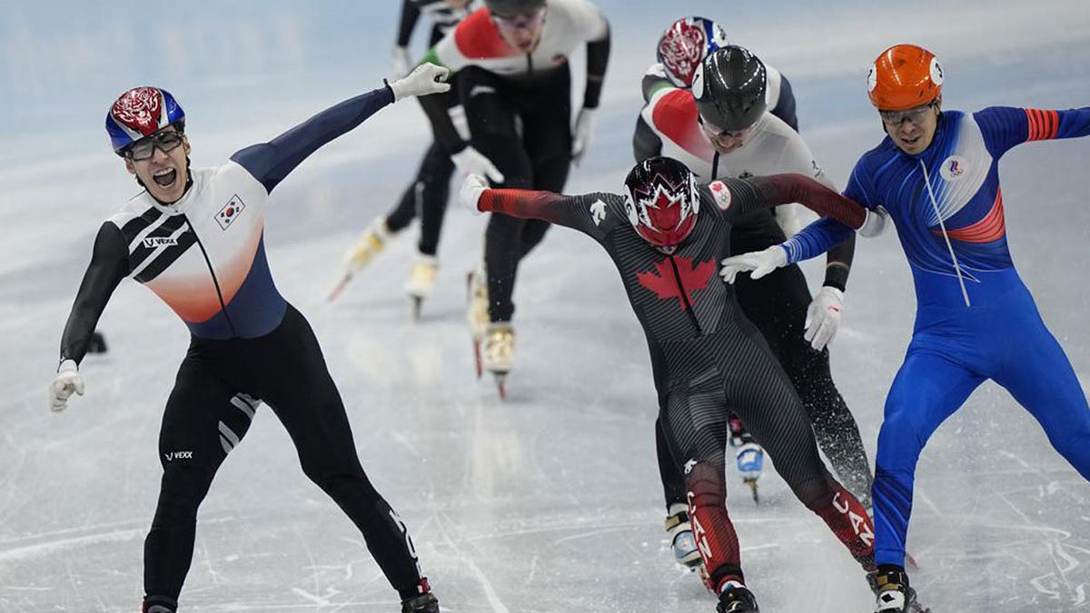 Hwang Dae-heon, left, of South Korea, reacts after winning his men's 1500-meters final during the short track speedskating competition at the 2022 Winter Olympics, Wednesday, Feb. 9, 2022, in Beijing.