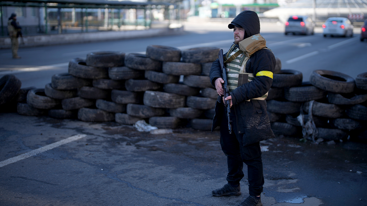 A civil defense member stands at a checkpoint in Kyiv, Ukraine, Saturday, Feb. 26, 2022.