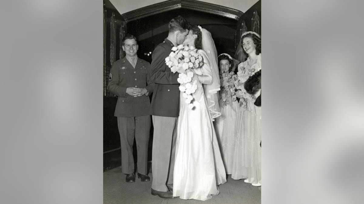 Charles and Mary Alice Stanley, kissing outside the church after their wedding ceremony.