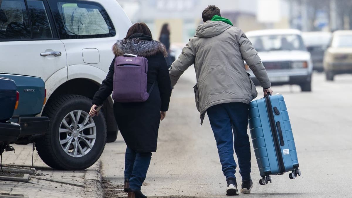 People are seen with suitcases after Russia's military operation on February 24, 2022, in Kramatorsk, Ukraine.
