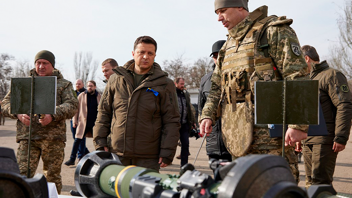 In this handout photo provided by the Ukrainian Presidential Press Office, Ukrainian President Volodymyr Zelenskyy, center, inspects weapons during a visit to Ukrainian coast guards in Mariupol, Donetsk region, eastern Ukraine, Thursday, Feb. 17, 2022.