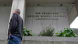 A pedestrian walks past a San Francisco Unified School District office building in San Francisco, Thursday, Feb. 3, 2022. (AP Photo/Jeff Chiu)