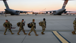 FORT BRAGG, NC - FEBRUARY 14: Soldiers with the 82nd Airborne division walk across the tarmac at Green Ramp to deploy to Poland on February 14, 2022 at Fort Bragg, Fayetteville, North Carolina. An estimated three thousand soldiers will be deployed as tensions rise in Eastern Europe. (Photo by Melissa Sue Gerrits/Getty Images)