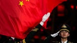 A Chinese flag is raised during a medal ceremony for the women's freestyle skiing big air at the 2022 Winter Olympics