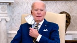 President Joe Biden removes his protective face mask before speaking during a meeting with the Qatar's Emir Sheikh Tamim bin Hamad Al Thani in the Oval Office of the White House, Monday, Jan. 31, 2022, in Washington.