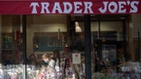 NEW YORK, NEW YORK - APRIL 08: An employee is seen through a window working a register in a patch of sunlight at Trader Joe's in Chelsea amid the coronavirus pandemic on April 08, 2021 in New York City. After undergoing various shutdown orders for the past 12 months the city is currently in phase 4 of its reopening plan, allowing for the reopening of low-risk outdoor activities, movie and television productions, indoor dining as well as the opening of movie theaters, all with capacity restrictions. (Photo by Alexi Rosenfeld/Getty Images)