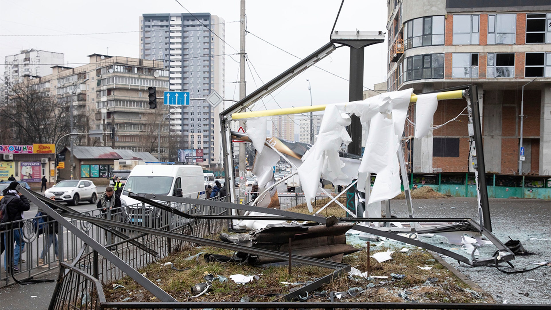 People walk past the consequences of Russian shelling in Kyiv, Ukraine, Thursday, Feb. 24, 2022.