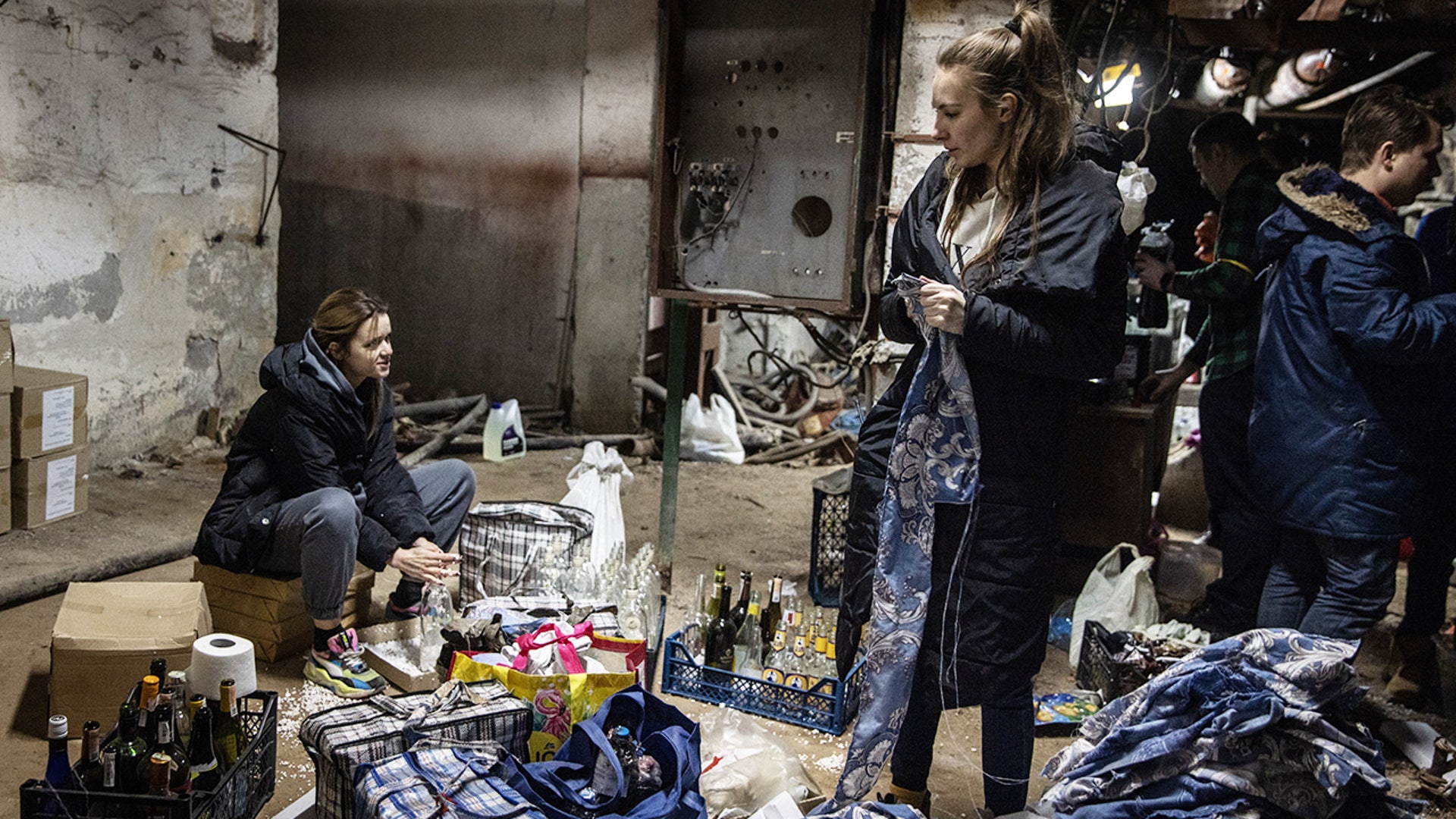 Volunteers work to make molotov cocktails in the basement of a bomb shelter on February 26, 2022 in Kyiv, Ukraine. Explosions and gunfire were reported around Kyiv on the second night of Russia's invasion of Ukraine, which has killed scores and prompted widespread condemnation from US and European leaders.