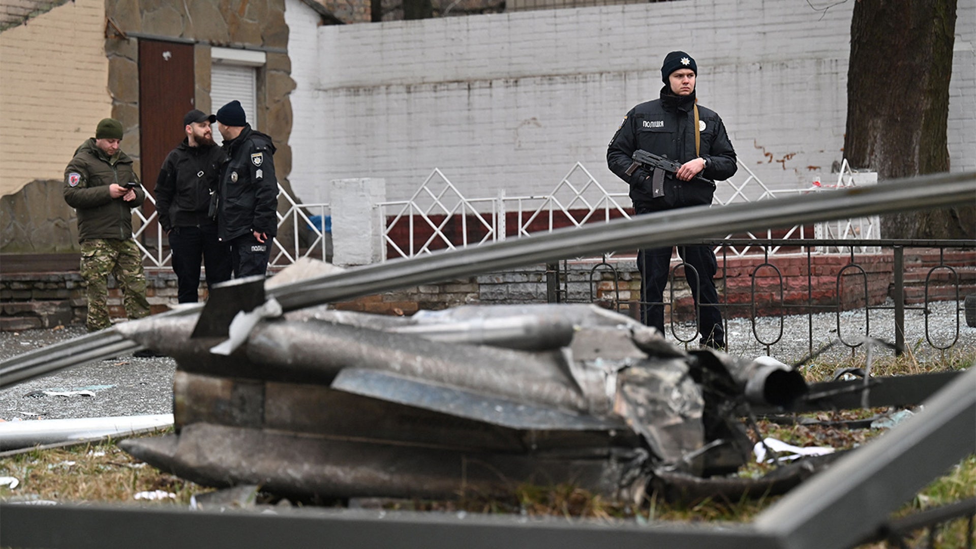 A police officer stands guard by the remains of a shell in Kyiv on February 24, 2022.