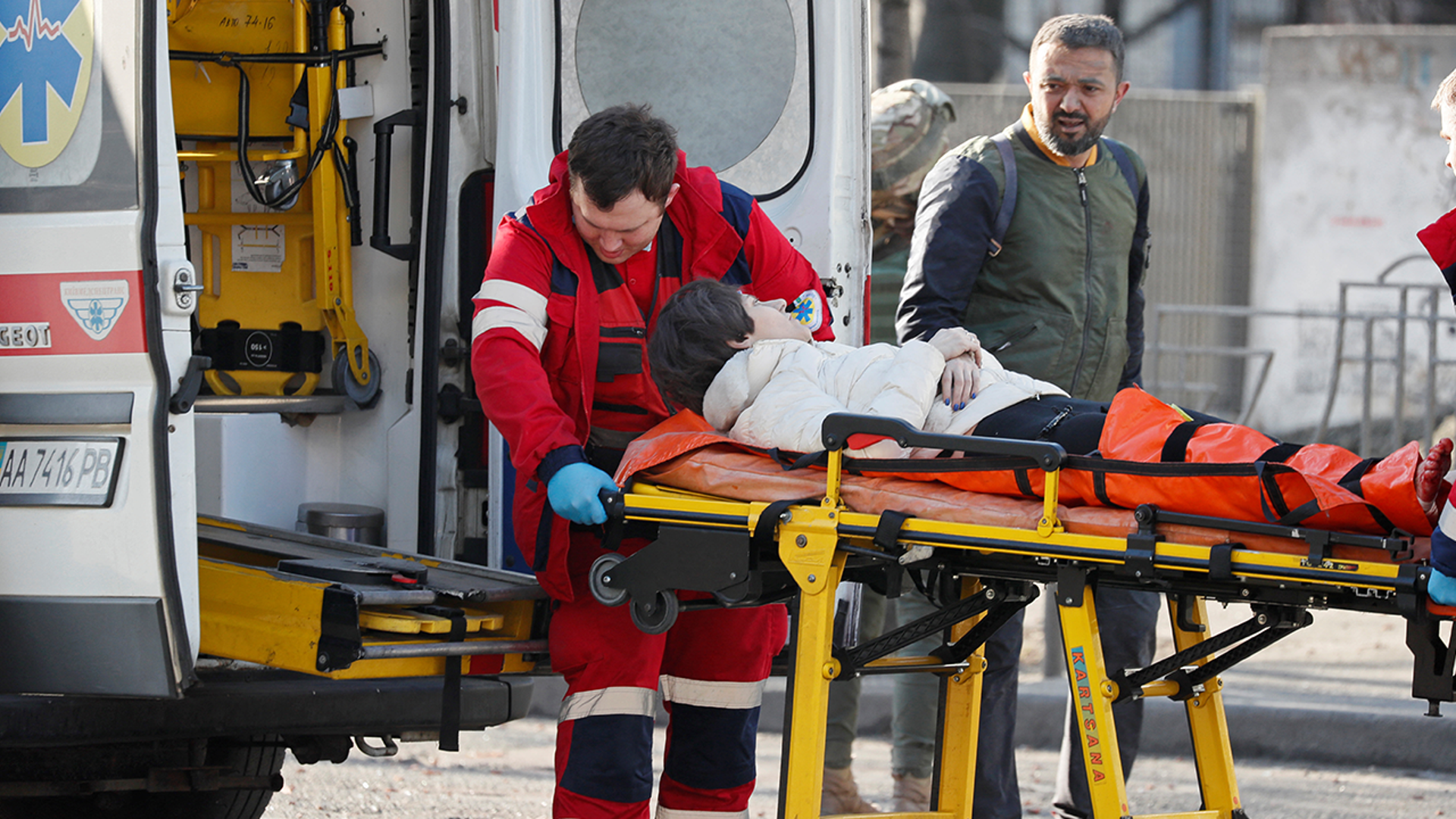 Medical specialists transport a woman, who was wounded in the shelling of an apartment building, to an ambulance, as her husband stands nearby, in Kyiv, Ukraine February 26, 2022