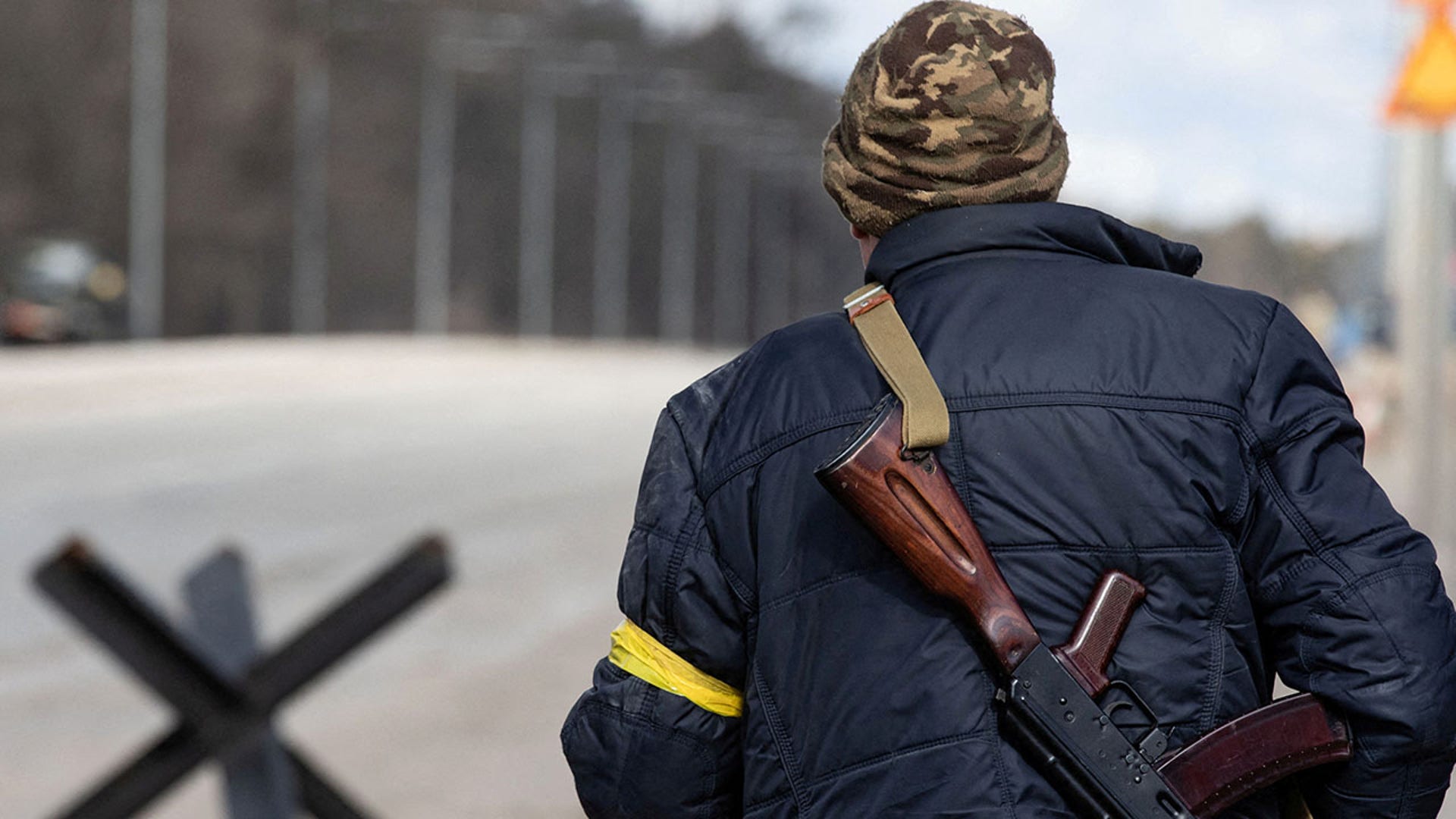 A member of the Territorial Defence Forces of Ukraine stands guard at a checkpoint on the outskirts of Kyiv, Ukraine February 27, 2022. REUTERS/Mikhail Palinchak   