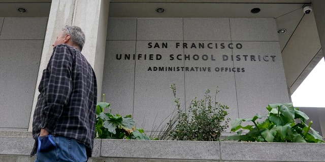 A pedestrian walks past a San Francisco Unified School District office building in San Francisco, Thursday, Feb. 3, 2022. Three members of the district's school board were recalled this week. 