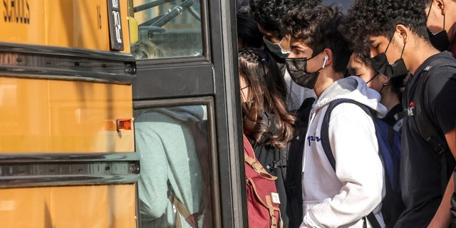 Students board a school bus outside a high school in January.