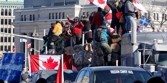 FILE PHOTO: Protestors stand on a trailer carrying logs as truckers and supporters take part in a convoy to protest coronavirus disease (COVID-19) vaccine mandates for cross-border truck drivers in Ottawa, Ontario, Canada, January 29, 2022.  REUTERS/Patrick Doyle/File Photo