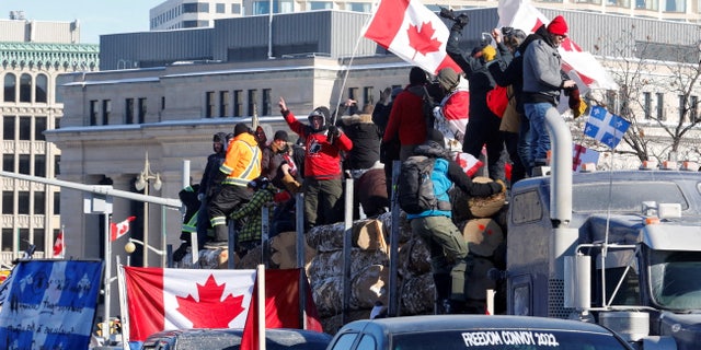 FILE PHOTO: Protestors stand on a trailer carrying logs as truckers and supporters take part in a convoy to protest coronavirus disease (COVID-19) vaccine mandates for cross-border truck drivers in Ottawa, Ontario, Canada, January 29, 2022. REUTERS/Patrick Doyle/File Photo