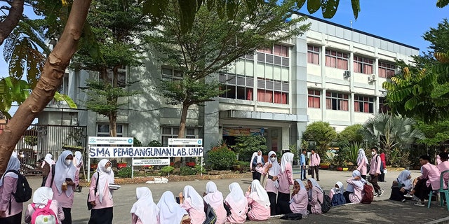 Siswa sekolah dasar mengevakuasi gedung sekolah setelah gempa berkekuatan 6,2 melanda pulau Sumatera, Indonesia, 25 Februari 2022.
