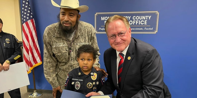 Devarjaye "D.J." Daniel, 10, is sworn into his 100th law enforcement agency. (Montgomery County Judge Mark Keough)