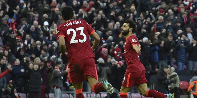 Liverpool's Mohamed Salah, right, celebrates after scoring his sides second goal during the English Premier League soccer match between Liverpool and Norwich City and at Anfield stadium in Liverpool, England, Saturday, Feb.  19, 2022. 