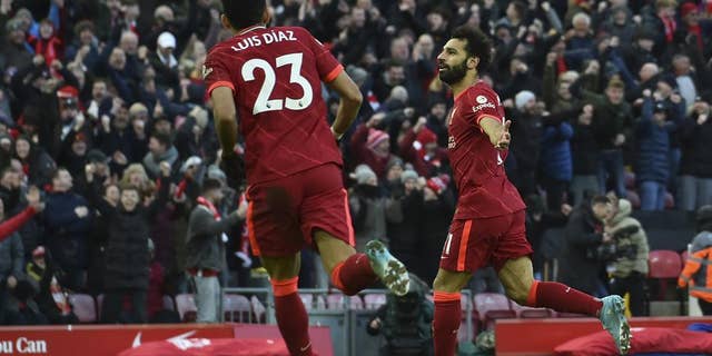 Liverpool's Mohamed Salah, right, celebrates after scoring his sides second goal during the English Premier League soccer match between Liverpool and Norwich City and at Anfield stadium in Liverpool, England, Saturday, Feb. 19, 2022.