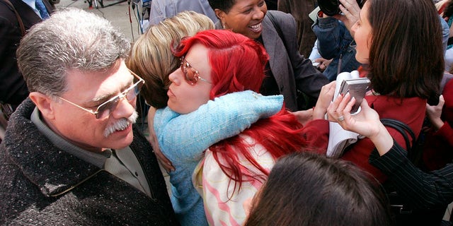 Juror Richelle Nice, center, hugs attorney Gloria Allred after speaking at a news conference after the formal sentencing of Scott Peterson in Redwood City, Calif., March 16, 2005.