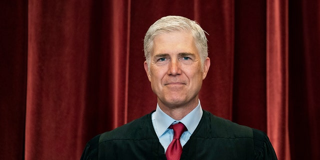 Le juge associé Neil Gorsuch se tient debout lors d'une photo de groupe à la Cour suprême de Washington, le 23 avril 2021.