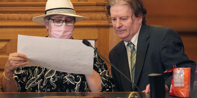 Kansas state Reps. Brenda Landwehr, left, R-Wichita, and Steve Huebert, R-Valley Center, confer during a meeting of a House committee on redistricting at the Statehouse in Topeka, Jan. 18, 2022.