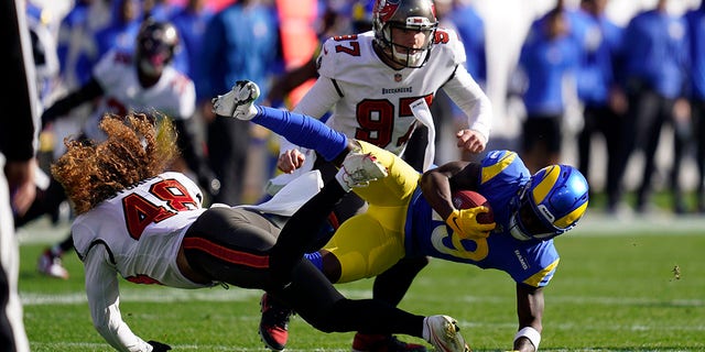 Tampa Bay Buccaneers linebacker Grant Stuard (48) upendes Los Angeles Rams wide receiver Brandon Powell (19) during the first half of an NFL divisional round playoff football game Sunday, Jan. 23, 2022, in Tampa, Fla.