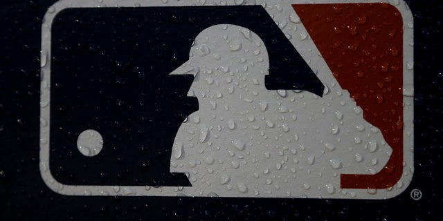 FILE - A rain-covered logo is seen at Fenway Park before Game 1 of the World Series baseball game between the Boston Red Sox and the Los Angeles Dodgers Tuesday, Oct.  23, 2018, in Boston.  The mood for Major League Baseball fans is a little glum these days as the players' union and owners continue to bicker over finances.  The owners locked out the players on Dec.  2 and unless an agreement between the two sides is reached soon, the spring training schedule is in trouble.  The first games are slated for Feb.  26, 2022.