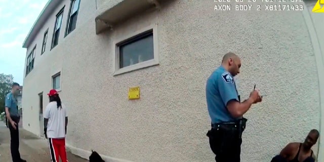 FILE - In this image from police body camera video shown as evidence in court, Minneapolis police Officers Thomas Lane, left, and J. Alexander Kueng, second from right, gather information as they take George Floyd into custody outside Cup Foods in Minneapolis, on May 25, 2020.