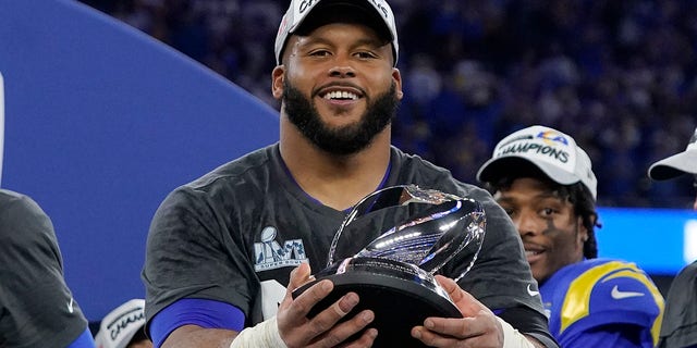 The Los Angeles Rams' Aaron Donald holds the George Halas trophy after the NFC Championship NFL football game against the San Francisco 49ers Sunday, Jan. 30, 2022, in Inglewood, California. The Rams won 20-17 to advance to the Super Bowl.