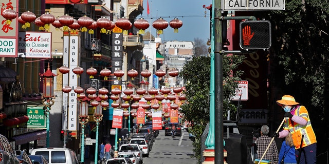 A worker cleans a street Friday, Jan. 31, 2020, in the Chinatown district in San Francisco. 
